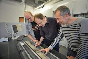 © Dr. Lars Wörmer, Prof. Kai-Uwe Hinrichs und Dr. Marcus Elvert (von links) inspizieren einen Bohrkern, der dunkle Faulschlammlagen enthält.